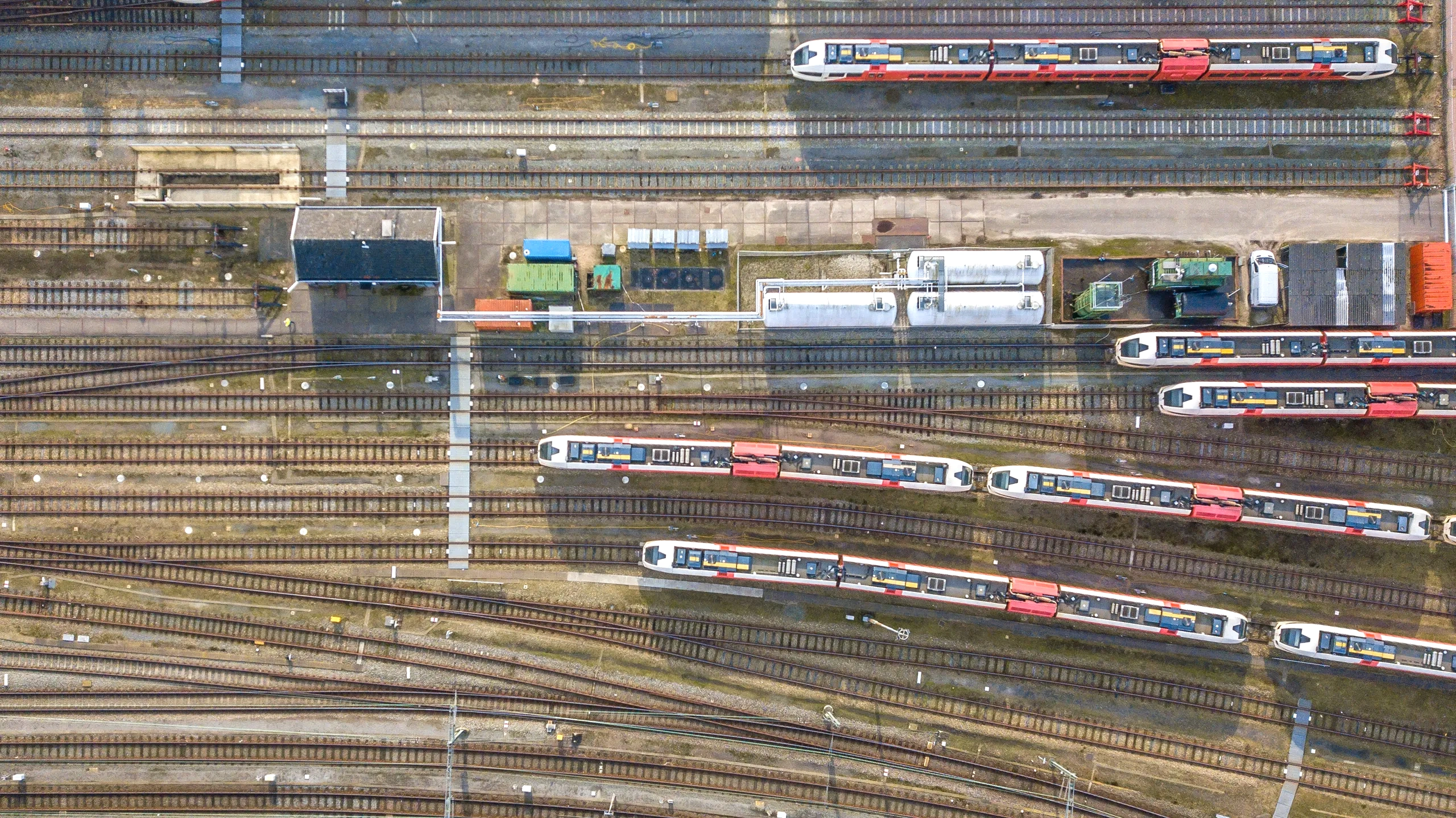Passenger trains, tracks and service buildings at a rail depot, seen from above